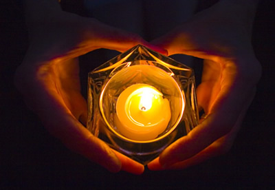 Carols Hands, photograph of Carol's hands holding a candle at night